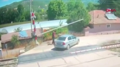 Bariyeri eliyle kaldırmaya çalıştı, otomobiline tren çarptı